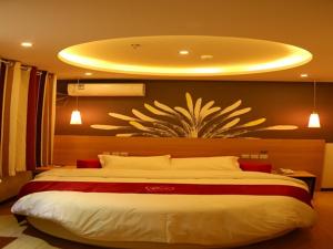 1 dormitorio con 1 cama grande y una gran pintura en la pared en Thank Inn Chain Hotel hubei wuhan caidian district lianhua lake avenue, en Wuhan
