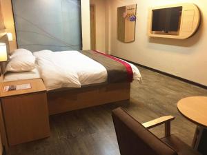a hotel room with a bed and a tv at Thank Inn Chain Hotel guangxi liuzhou luzhai county square in Liuzhou