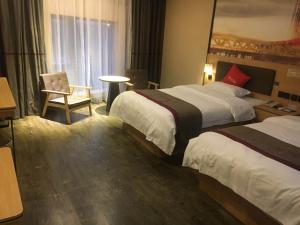 a hotel room with two beds and a chair at Thank Inn Chain Hotel sichuan guang'an yuechi rongxinyue city in Guang'an