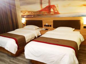 Dos camas en una habitación de hotel con un puente en el fondo en Thank Inn Chain Hotel shandong heze juye county shanghai jiayuan, en Heze