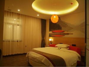 een slaapkamer met een groot bed en een kroonluchter bij Thank Inn Chain Hotel anhui huinan shou county rose residence in Huainan