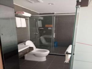 a bathroom with a toilet and a glass shower at Thank Inn Chain Hotel xizang changdu basu county county in Baima