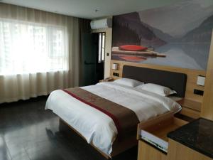 a bedroom with a large bed with a painting on the wall at Thank Inn Chain Hotel Shanxi jinzhong Taigu County xingangwan shopping plaza in Jinzhong