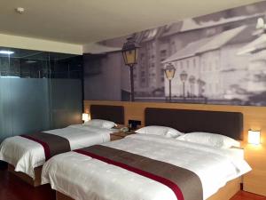 2 Betten in einem Hotelzimmer mit Wandgemälde in der Unterkunft Thank Inn Chain Hotel Fujian Quanzhou Anxi County Yongan Road in Quanzhou