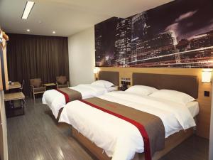 duas camas num quarto de hotel com uma fotografia na parede em Thank Inn Chain Hotel Jiangsu Suzhou Taihu Lake Dongshan Town em Suzhou
