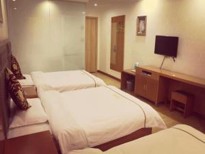 ein Hotelzimmer mit 2 Betten und einem TV in der Unterkunft Thank Inn Chain Hotel shanxi yulin yuyang district railway station in Yulin