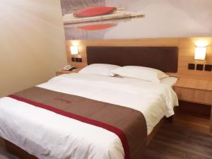 um quarto com uma grande cama branca e 2 almofadas em Thank Inn Chain Hotel shandong heze juye county shanghai jiayuan em Heze