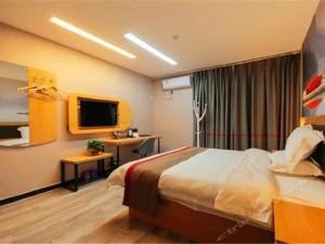 a hotel room with a bed and a television at Thank Inn Chain Hotel henan zhengzhou future road convention and exhibition center in Zhengzhou