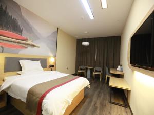 a hotel room with a bed and a table with chairs at Thank Inn Chain Hotel Xiangyang east railway station in hubei province in Xiangyang