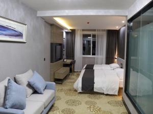 Habitación de hotel con 2 camas y sofá en Thank Inn Plus Hotel Jiangsu huaian huaiyin area of the Yangtze river east road, en Huai'an