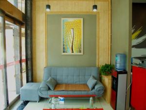 sala de estar con sofá azul y mesa en Thank Inn Chain Hotel henan kaifeng jinming district xinghuaying town government, en Kaifeng