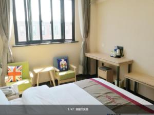 a bedroom with a bed and chairs and a window at Thank Inn Chain Hotel Shanghai jinshan, jinshan new town in Nanhui