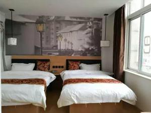 twee bedden in een kamer met een schilderij aan de muur bij Thank Inn Chain Hotel Jiangsu suzhou kunshan foxconn in Suzhou
