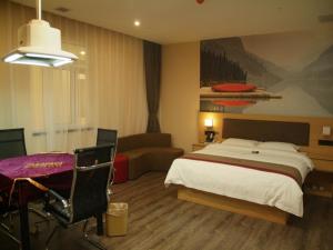 a hotel room with a bed and a table and a chair at Thank Inn Chain Hotel anhui huinan shou county rose residence in Huainan