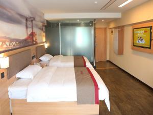 um quarto com uma cama grande e uma televisão em Thank Inn Chain Hotel Jiangsu Yancheng Funing County Jinsha Lake em Yancheng