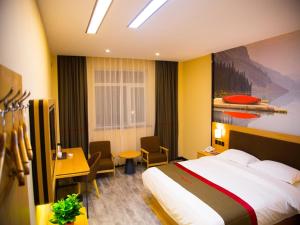 a hotel room with a bed and a table and chairs at Thank Inn Chain Hotel gansu tianshui maiji district xihuang avenue in Tianshui