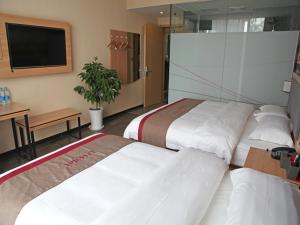 um quarto de hotel com duas camas e uma televisão de ecrã plano em Thank Inn Chain Hotel Jiangsu huaian industrial park chunhui road em Huai'an