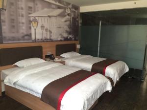 two beds in a hotel room at Thank Inn Chain Hotel Fujian Quanzhou Anxi County Yongan Road in Quanzhou