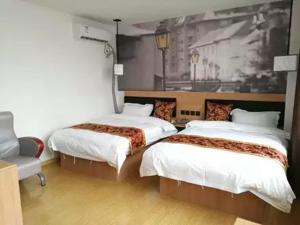 two beds in a room with a painting on the wall at Thank Inn Chain Hotel Jiangsu suzhou kunshan foxconn in Suzhou