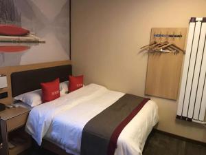 um quarto com uma cama grande e almofadas vermelhas em Thank Inn Chain Hotel gansu lanzhou chengguan district oriental red square em Lanzhou
