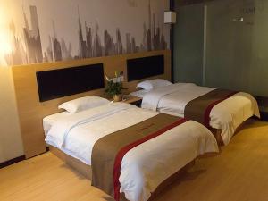 a hotel room with two beds and a painting on the wall at Thank Inn Chain Hotel Shanxi xianyang train station in Xianyang