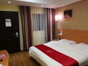 um quarto com uma cama grande e um cobertor vermelho e branco em Thank Inn Chain Hotel guizhou anshun huangguoshu scenic area em Anshun