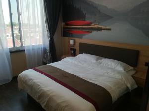 - un grand lit dans une chambre avec une grande fenêtre dans l'établissement Thank Inn Chain Hotel jiangsu xuzhou jiawang district biantang county, à Xuzhou