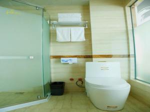 a bathroom with a shower and a toilet and towels at Thank Inn Chain Hotel henan kaifeng jinming district xinghuaying town government in Kaifeng