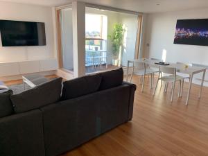 a living room with a couch and a dining room at Toothbrush Apartments - Ipswich Waterfront - Quayside in Ipswich