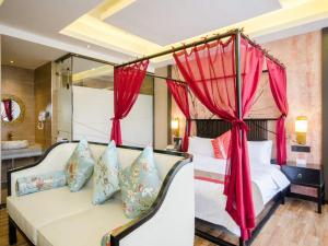a bedroom with two beds with red curtains and a couch at Thank Inn Chain Hotel Shanxi Linfen Central square of Hongtong county in Linfen