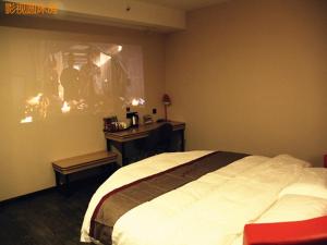 a bedroom with a large bed and a desk at Thank Inn Chain Hotel shanxi xianyang sanyuan county yuyuan road in Xianyang