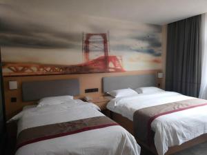 two beds in a hotel room with a painting on the wall at Thank Inn Chain Hotel xizang changdu basu county county in Baima