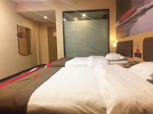 un grande letto in una camera d'albergo con un grande letto bianco di Thank Inn Chain Hotel guangxi liuzhou luzhai county square a Liuzhou