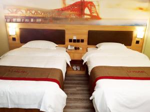 duas camas num quarto com uma ponte ao fundo em Thank Inn Chain Hotel shandong heze juye county shanghai jiayuan em Heze