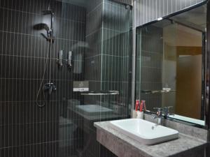 uma casa de banho com um lavatório e um chuveiro em Thank Inn Chain Hotel henan luoyang mengjin county huimeng avenue bilingual school em Luoyang