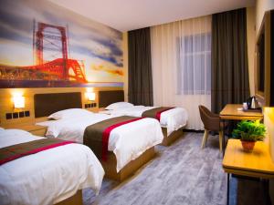 a hotel room with four beds and a painting on the wall at Thank Inn Chain Hotel gansu tianshui maiji district xihuang avenue in Tianshui