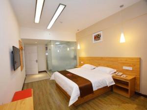a bedroom with a large bed and a sliding glass door at Thank Inn Chain Hotel henan zhengzhou fangte green expo park in Zhengzhou