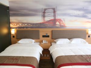 2 camas en una habitación de hotel con una montaña rusa en Thank Inn Chain Hotel Jiangsu Yancheng Funing County Jinsha Lake, en Yancheng