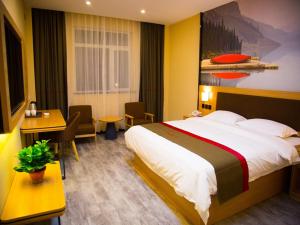 a hotel room with a bed and a table and chairs at Thank Inn Chain Hotel gansu tianshui maiji district xihuang avenue in Tianshui