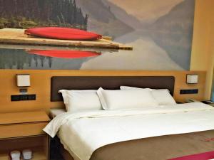 a bedroom with a bed and a painting of a boat at Thank Inn Chain Hotel sichuan luzhou longmatan district kaixuan city in Luzhou
