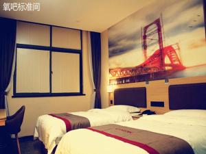 a hotel room with two beds and a painting of a tower at Thank Inn Chain Hotel shanxi xianyang sanyuan county yuyuan road in Xianyang
