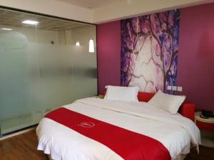 una camera da letto con un grande letto con una coperta rossa e bianca di Thank Inn Chain Hotel guizhou anshun huangguoshu scenic area ad Anshun