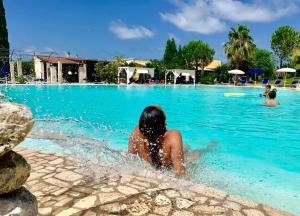 une femme dans l'eau d'une piscine dans l'établissement Villa Conca Marco, à Vanze