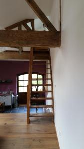 a living room with a wooden staircase in a house at Le Peyroutet in Cazaux-Villecomtal
