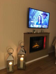 uma sala de estar com lareira com velas e uma televisão em Ferienwohnung Gute Zeit Hahnenklee em Hahnenklee-Bockswiese