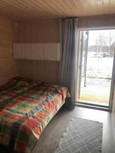 een slaapkamer met een bed en een groot raam bij Willa Pihlaja in Punkaharju