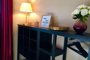a table with a vase of flowers and a lamp at Ferienwohnung Gute Zeit Hahnenklee in Hahnenklee-Bockswiese