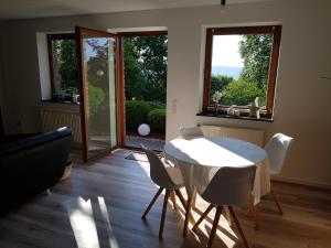 sala de estar con mesa blanca y sillas en Garden & Hill Ferienwohnung Limburg, en Simmerath
