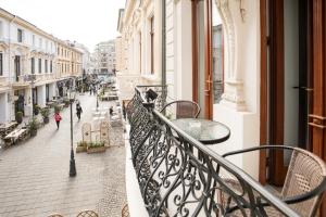 a balcony with tables and chairs on a city street at Concorde Old Bucharest Hotel in Bucharest
