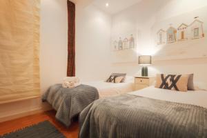 Duas camas num quarto com paredes brancas em Centro del Casco viejo Órigenes y tradición em Bilbau